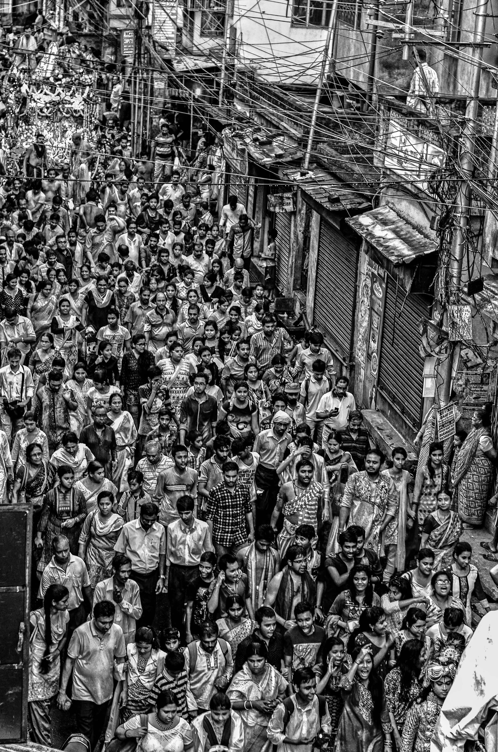 Black-and-white photograph of a densely crowded Indian street