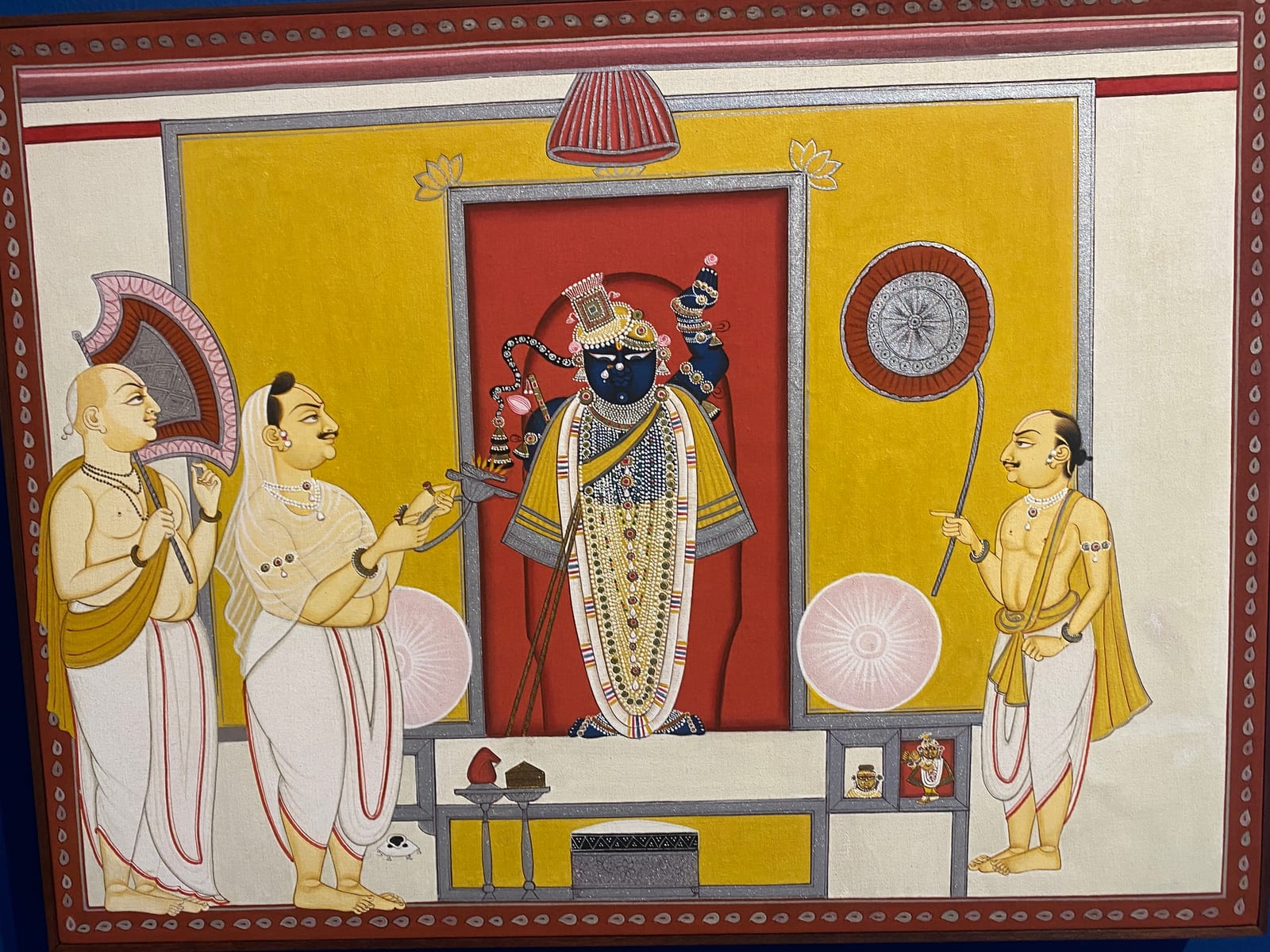 Pichvai of Shrinathji on a yellow shrine flanked by priests with drums