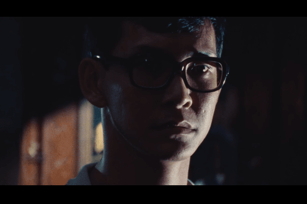 Film still from 12 Storeys of a young man in glasses